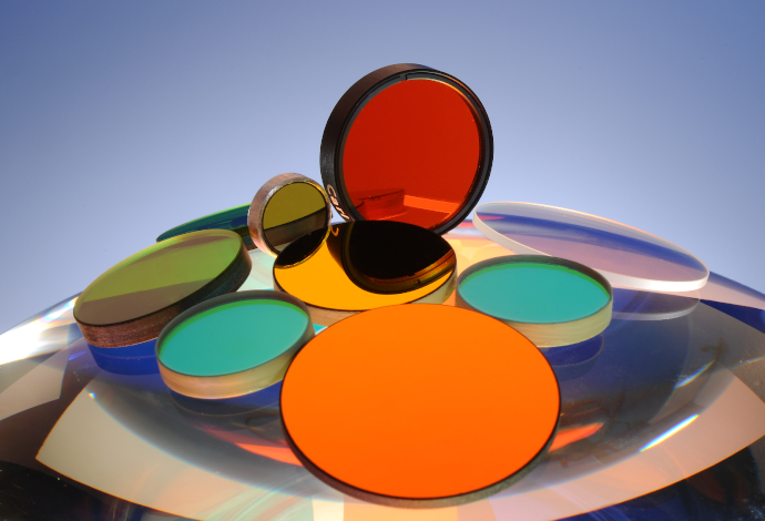 Large collections of optical filter glass and thin film coatings combine to create a vast range of customer options Collection of glass discs of different colors