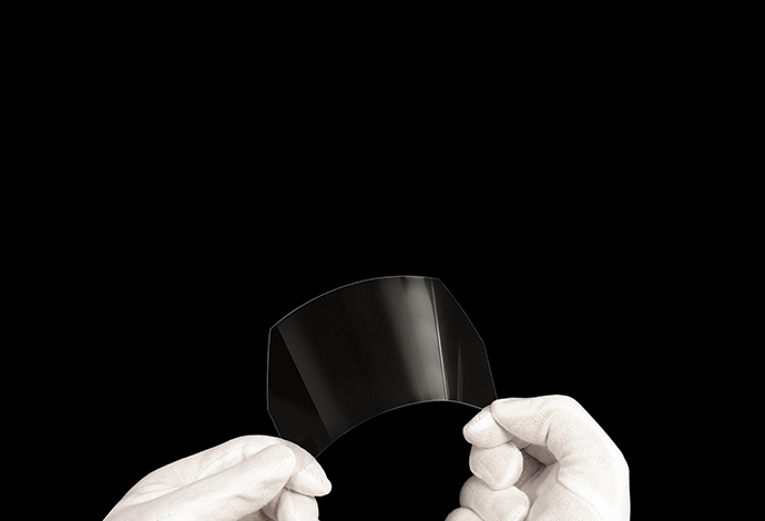 SCHOTT® Solar Glass 0787 is available in a range of thicknesses, sizes and coatings Two hands in white gloves bending ultra-thin glass