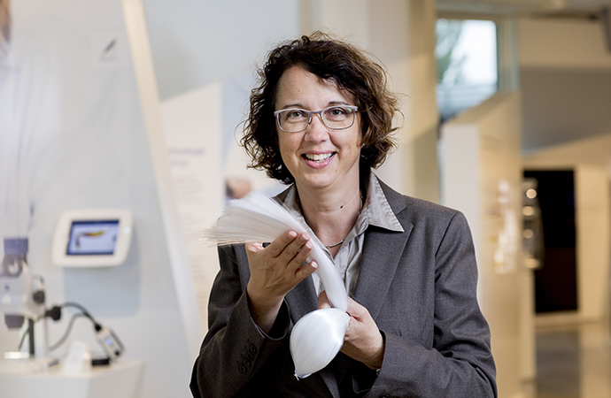 Karen Holst, Senior Product Manager for Medical at SCHOTT Lighting and Imaging, holding a bunch of PURAVIS® glass optical fibers