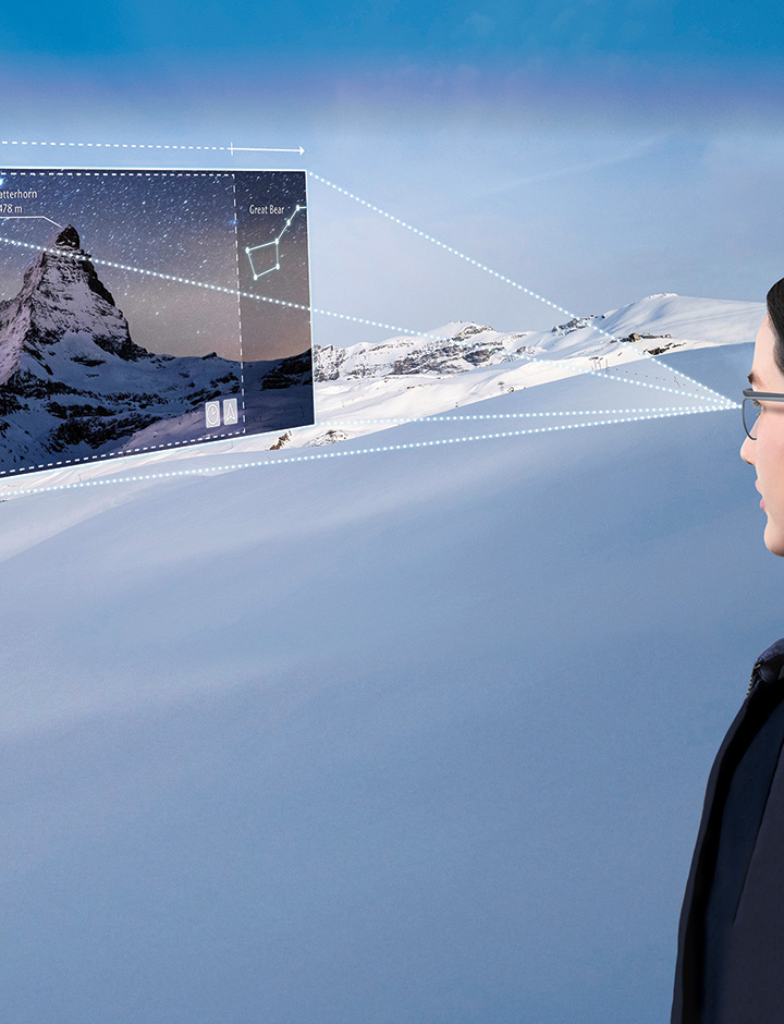 Young woman on a mountain wearing smart glasses looking at an augmented reality image 
